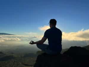 sitting on top of a mountain while meditating